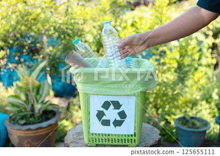 Plastic bottle waste for recycling, reuse concept. Volunteers store plastic bottles in cardboard boxes at a park. Disposal, recycling and waste management. Good conscience. 125655111