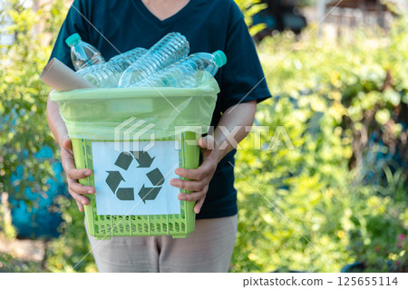 Plastic bottle waste for recycling, reuse concept. Volunteers store plastic bottles in cardboard boxes at a park. Disposal, recycling and waste management. Good conscience. 125655114