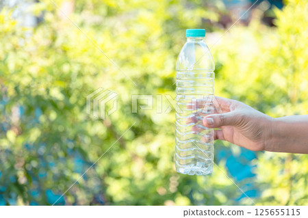 Plastic bottle waste for recycling, reuse concept. Volunteers store plastic bottles in cardboard boxes at a park. Disposal, recycling and waste management. Good conscience. 125655115