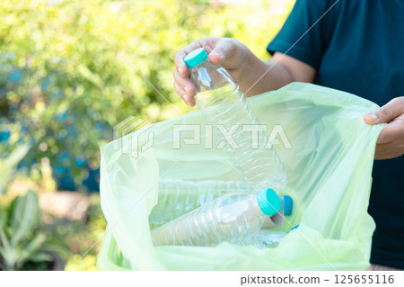 Plastic bottle waste for recycling, reuse concept. Volunteers store plastic bottles in cardboard boxes at a park. Disposal, recycling and waste management. Good conscience. 125655116