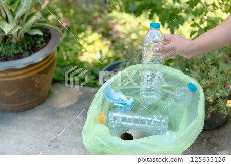 Plastic bottle waste for recycling, reuse concept. Volunteers store plastic bottles in cardboard boxes at a park. Disposal, recycling and waste management. Good conscience. 125655126