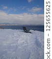 Looking out at the winter sea from a bench 125655625