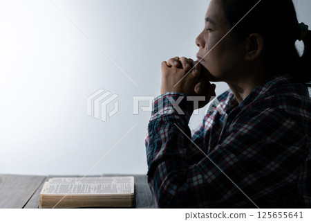 Christian life crisis prayer to god. Woman Pray for god blessing to wishing have a better life. woman hands praying to god with the bible. begging for forgiveness and believe in goodness. 125655641