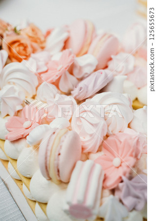 Pastel Macarons and Flowers on Cake 125655673