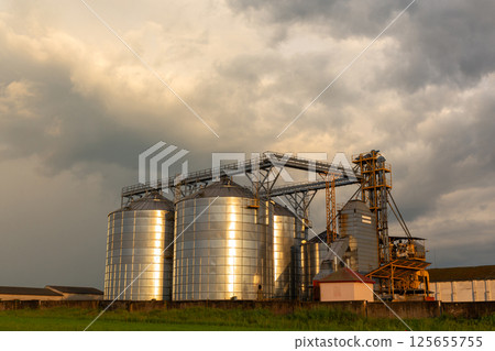 A captivating sunset over a grain dryer and hopper 125655755