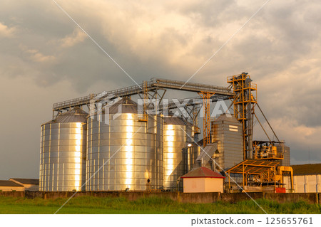 A captivating sunset over a grain dryer and hopper 125655761