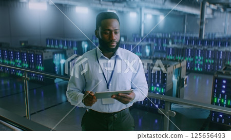 Big Data Center with Server Racks: Professional Specialist Using Tablet Computer, Activating Servers Big Data Center with Server Racks: Professional Specialist Using Tablet Computer, Activating Servers 125656493