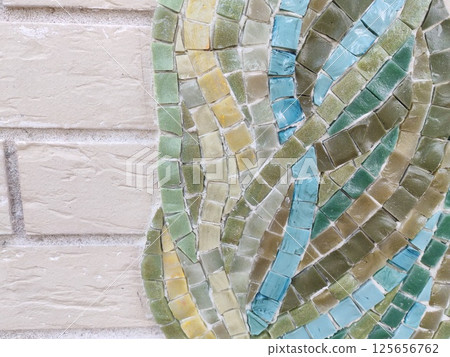 An artistic mosaic of small tiles in natural shades of blue, green, and yellow. The intricate arrangement creates a visually engaging texture. An artistic mosaic of small tiles in natural shades of blue, green, and yellow. The intricate arrangement creates a visually engaging texture. 125656762