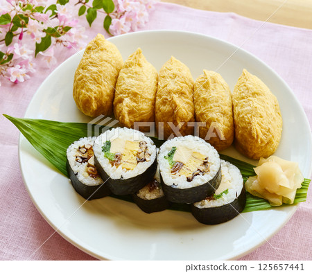 Spring Japanese-style lunch plate with sushi rolls and inari sushi 125657441