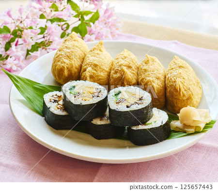 Spring Japanese-style lunch plate with sushi rolls and inari sushi Spring Japanese-style lunch plate with sushi rolls and inari sushi 125657443