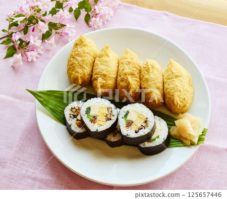 Spring Japanese-style lunch plate with sushi rolls and inari sushi Spring Japanese-style lunch plate with sushi rolls and inari sushi 125657446