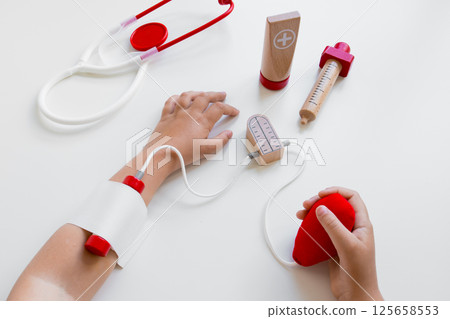 Child hands playing with toy medical set on white background 125658553