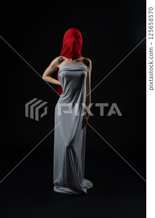 Model poses in a dramatic fashion casting with a striking red headscarf 125658570