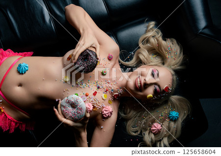 Beauty and body art combine with playful desserts in a vibrant setting 125658604