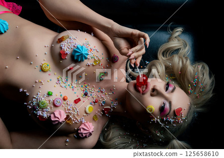 Beauty in body art with colorful candy designs on display in an artistic setting 125658610