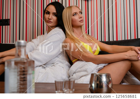 Women posing in lingerie with colorful striped background in modern setting Women posing in lingerie with colorful striped background in modern setting 125658681