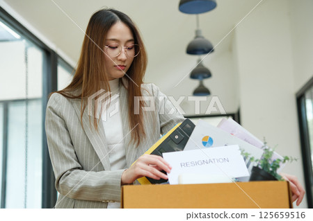 Resignation concept. Businesswoman packing personal belongings deciding resignation change of job or fired from the company. 125659516