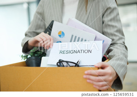 Resignation concept. Businesswoman packing personal belongings deciding resignation change of job or fired from the company. 125659531