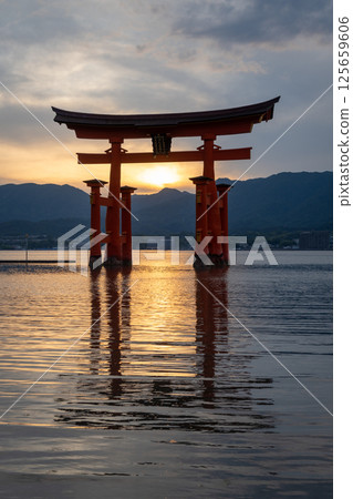 Famous red torii gate of Itsukushima shrine at sunset in Miyajima, Japan 125659606