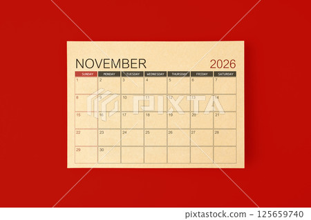 November 2026 desk calendar made from brown paper page on red background. 125659740
