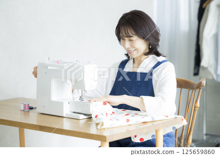 Woman doing dressmaking at home Woman doing dressmaking at home 125659860