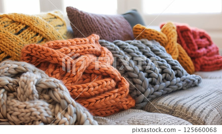 Knitted home decor adds warmth and texture, enhancing a room's cozy feel with blankets and pillow covers. Knitted home decor adds warmth and texture, enhancing a room's cozy feel with blankets and pillow covers. 125660068