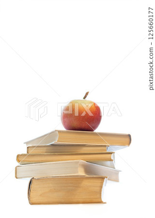 Stack of old hardcover books with red apple on top, centered on white background with copy space. 125660177