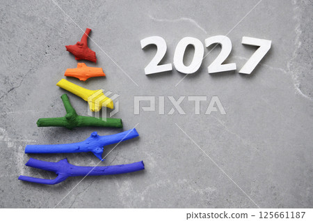 Flat lay stylized Christmas tree made of small twigs painted in rainbow colors on stone background. New 2027 year. Space for text Flat lay stylized Christmas tree made of small twigs painted in rainbow colors on stone background. New 2027 year. Space for text 125661187