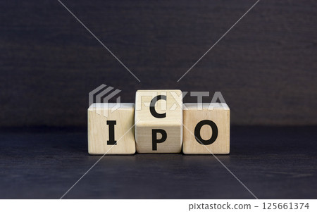 Initial public or coin offering symbol. Concept words abbreviation IPO or ICO on wooden block. Beautiful black table black background. Business Initial public or coin offering concept. Copy space. 125661374