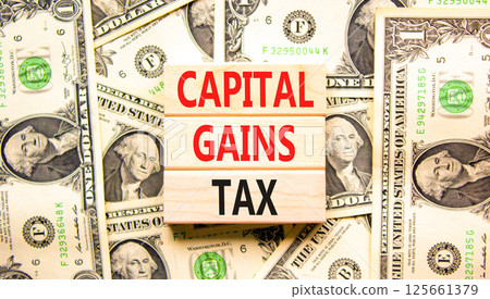 Capital gains tax symbol. Concept words Capital gains tax on beautiful wooden blocks. Dollar bills. Beautiful background from dollar bills. Business and capital gains tax concept. Copy space. Capital gains tax symbol. Concept words Capital gains tax on beautiful wooden blocks. Dollar bills. Beautiful background from dollar bills. Business and capital gains tax concept. Copy space. 125661379