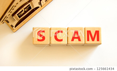 Scam symbol. Concept word Scam on beautiful wooden blocks. Beautiful wooden house. Beautiful white table white background. Business, lifestyle, support and scam concept. Copy space. 125661434