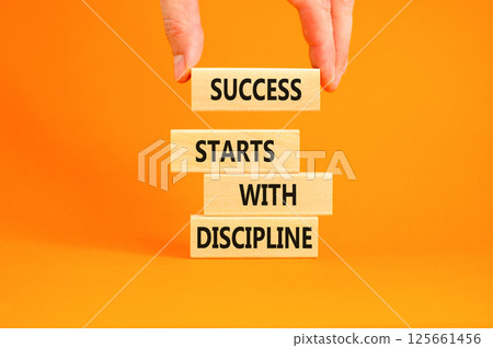Success starts with discipline symbol. Concept words Success starts with discipline on beautiful wooden blocks. Beautiful orange background. Business success starts with discipline concept. Copy space Success starts with discipline symbol. Concept words Success starts with discipline on beautiful wooden blocks. Beautiful orange background. Business success starts with discipline concept. Copy space 125661456