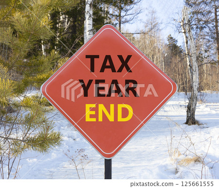 Tax year end symbol. Concept words Tax year end on beautiful red road sign. Beautiful snow forest background. Business tax year end concept. Copy space. Tax year end symbol. Concept words Tax year end on beautiful red road sign. Beautiful snow forest background. Business tax year end concept. Copy space. 125661555