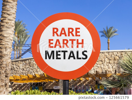 Rare earth metals symbol. Concept words Rare earth metals on beautiful big white road sign. Beautiful palm tree hotel blue sky background. Business and rare earth metals concept. Copy space. 125661579
