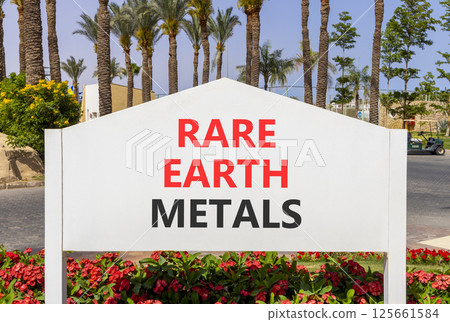 Rare earth metals symbol. Concept words Rare earth metals on beautiful big white road sign. Beautiful palm tree hotel background. Business and rare earth metals concept. Copy space. 125661584