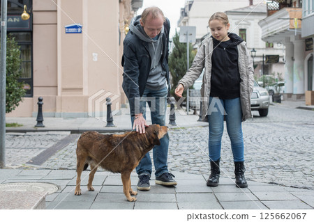 Father, his daughter and dog pet walking along the city streets 125662067