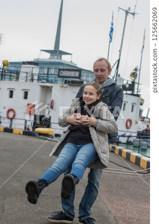 Father and his daughter child girl having fun outdoors. Weekend. Happy family together Father and his daughter child girl having fun outdoors. Weekend. Happy family together 125662069