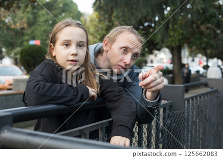 Curious daughter child girl and her father together looking at nature and pointing. Happy family 125662083