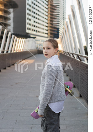 Beautiful young girl child in casual with skateboard outdoors Beautiful young girl child in casual with skateboard outdoors 125662274