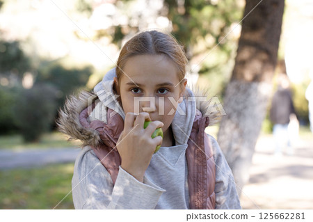 Portrait of young girl with apple fruit in park. Child 10 years old Portrait of young girl with apple fruit in park. Child 10 years old 125662281