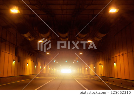 Empty long tunnel with yellow lamps on walls Empty long tunnel with yellow lamps on walls 125662310