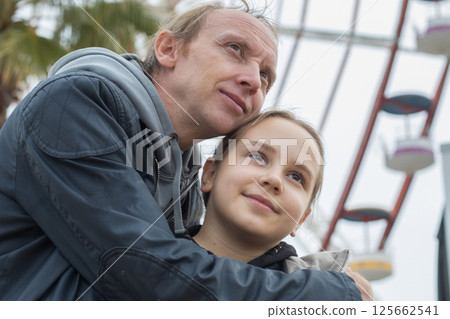 Cheerful daughter child girl and her father walking outdoors. Happiness, childhood and bonding  125662541