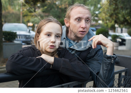 Excited daughter child girl and her father together looking at something and pointing. Happy family 125662561