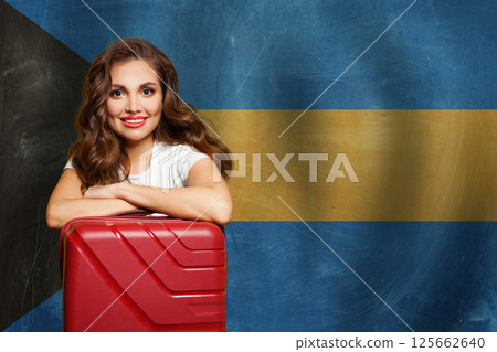 Bahamas concept. Beauty woman with red suitcase on Bahamas flag background. Travel, work, education  125662640