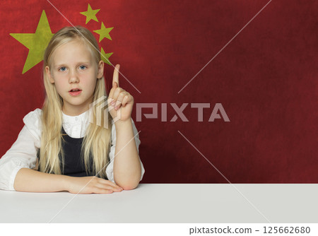 Curious young child girl pointing up on flag of China background.  125662680