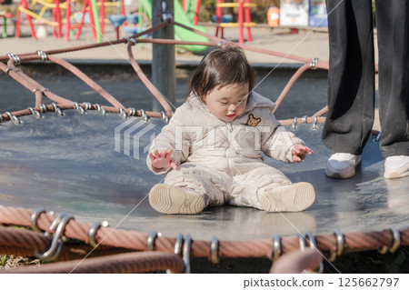 [相模原市麻溝公園兒童遊樂場，一歲小孩和媽媽在彈跳床上玩耍] 125662797