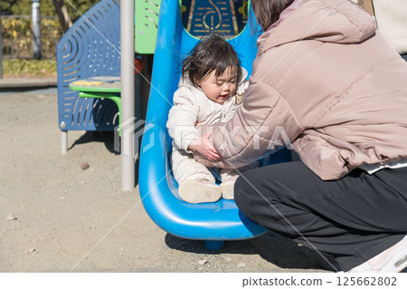 [一歲兒童與母親在相模原市麻溝公園的兒童遊樂場玩耍] 125662802