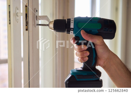 Engaging in DIY Home Improvement Projects with a Power Drill in a Stylish Modern Apartment 125662840