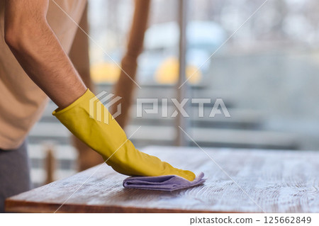 Effectively Cleaning A Table Surface With A Sponge For A Neat And Tidy Appearance 125662849