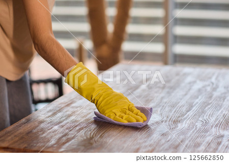 Effectively Cleaning A Table Surface With A Sponge For A Neat And Tidy Appearance 125662850